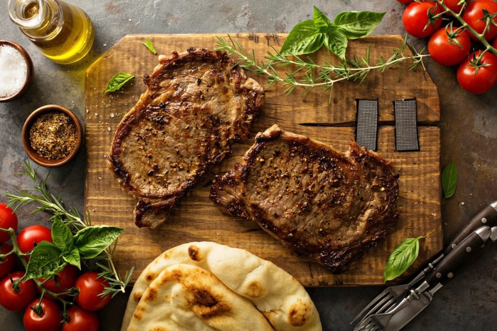 Grilled ribeye steaks on a wooden board