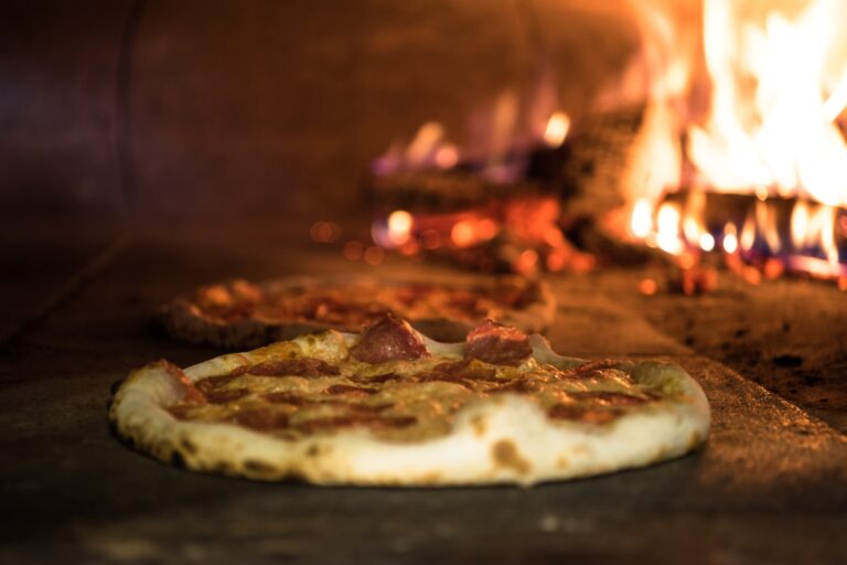 close up view of italian pizza baking in brick oven in restaurant