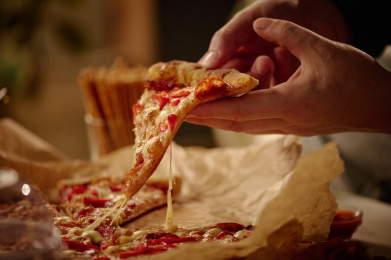 Holding Slice of Cheese Pizza With Melting Cheese